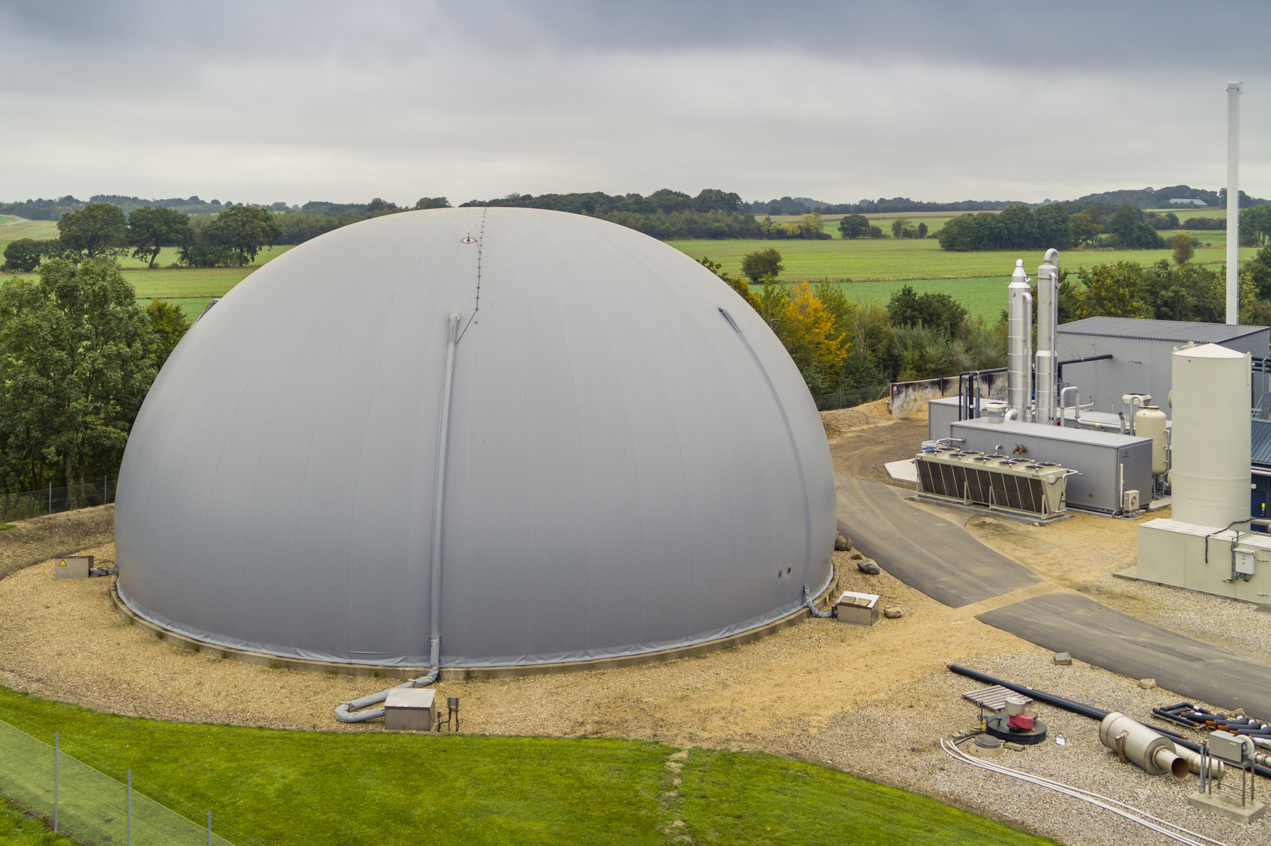 Aerial view of a European biomethane upgrading plant with anaerobic digesters — certified EU biogas production and cross-border trade